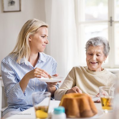 Mitarbeiterin und Gast beim Kuchen essen