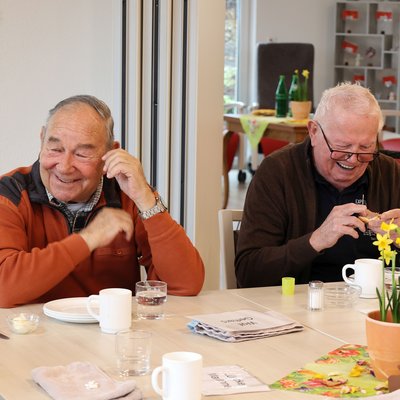 2 Gäste sitzen am Tisch und lachen