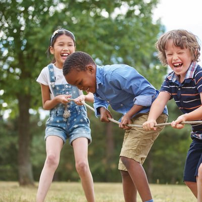 Kinder lachend beim Tauziehen