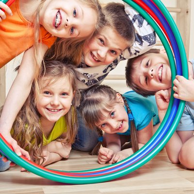 Kinder schauen durch einen Hula Hoop Reifen