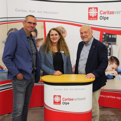 Geschäftsleitungen und Vorstand vor einer Messewand