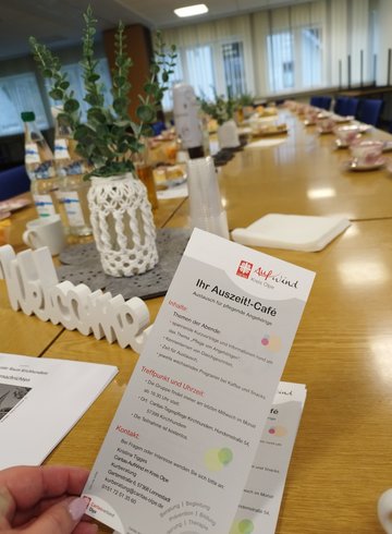 Hand mit Flyer vom Café