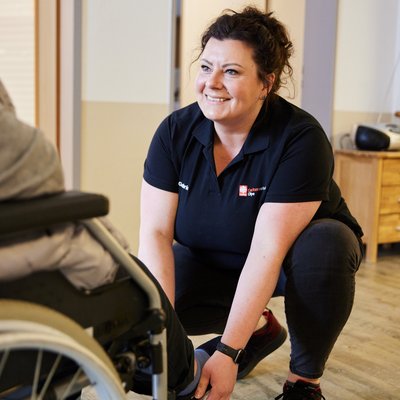 Mitarbeiterin mit Mann im Rollstuhl