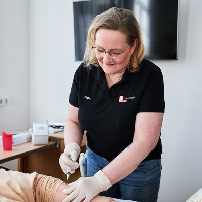 Auszubildene versorgt Übungspuppe