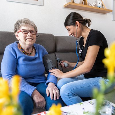 Pflegekraft misst Blutdruck bei Bewohnerin
